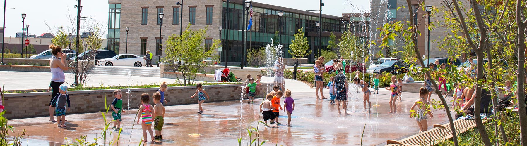 Kids playing on Splash Pad in front of Civic Center