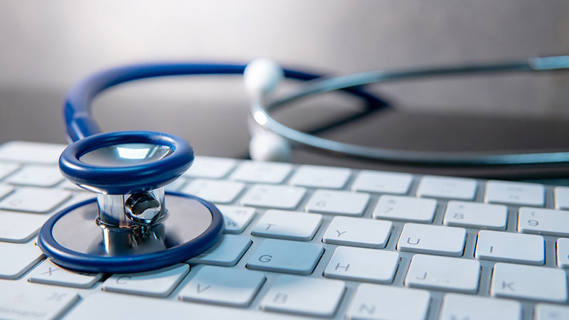 stethoscope sitting on top of a computer keyboard