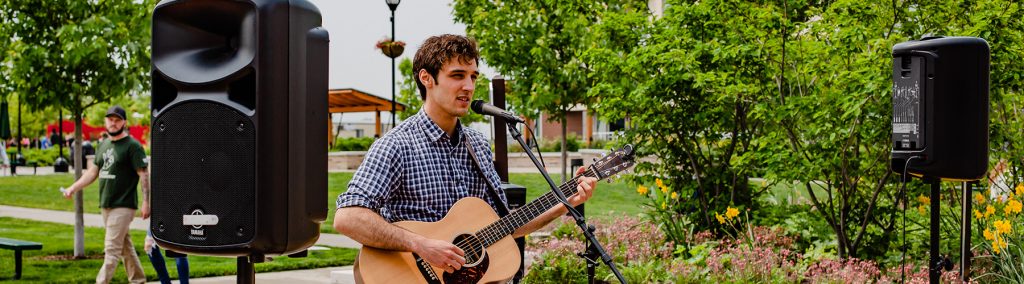 Musician playing guitar and singing at the farmers market