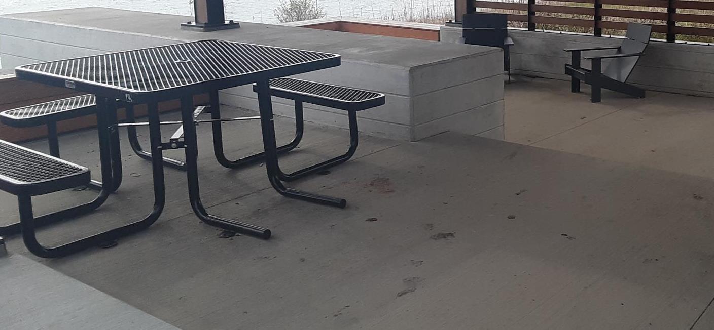 Black picnic table and two chairs cement patio