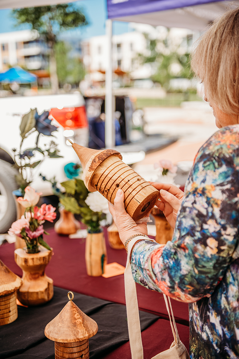 Woman examines handcrafted wooden birdhouse